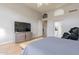 Large bedroom with hardwood floors, a TV above the dresser, and two open doorways at 9678 E Voltaire Dr, Scottsdale, AZ 85260