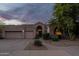 Charming home exterior boasting stucco walls, tile roof, mature trees, and arched entryway with a three-car garage at 9678 E Voltaire Dr, Scottsdale, AZ 85260