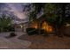 Lovely single-story home with a three-car garage, beautiful desert landscaping and warm lighting at 9678 E Voltaire Dr, Scottsdale, AZ 85260