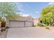 Home exterior featuring a tile roof and a three-car garage at 9678 E Voltaire Dr, Scottsdale, AZ 85260
