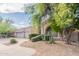 Exterior view showcasing the desert landscaping, curved walkway, and lush trees at 9678 E Voltaire Dr, Scottsdale, AZ 85260