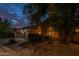 Inviting front exterior showcasing desert landscaping, a circular archway, and a spacious three-car garage at 9678 E Voltaire Dr, Scottsdale, AZ 85260