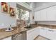 Well-lit kitchen featuring granite countertops, a stainless steel sink, and bright white cabinetry at 9678 E Voltaire Dr, Scottsdale, AZ 85260