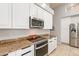 Modern kitchen featuring granite countertops, stainless steel appliances, and sleek white cabinetry at 9678 E Voltaire Dr, Scottsdale, AZ 85260