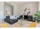 Modern living room with a black leather sectional sofa, glass tables, and artistic decor at 9678 E Voltaire Dr, Scottsdale, AZ 85260