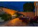 Outdoor dining area with elegant seating and a cozy fire pit, set against a beautifully landscaped wall at 9678 E Voltaire Dr, Scottsdale, AZ 85260