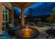 Relaxing outdoor space with a fire pit, plush seating, and a view of the pool and lush landscaping at 9678 E Voltaire Dr, Scottsdale, AZ 85260
