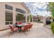 Back patio with an outdoor dining table with six chairs, travertine tile, and views of the backyard at 9678 E Voltaire Dr, Scottsdale, AZ 85260