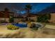 Landscaped backyard features a private pool with rock features and a lush patio with palm trees at 9678 E Voltaire Dr, Scottsdale, AZ 85260