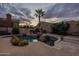 Lush backyard showcasing a pristine pool, rock features, a palm tree and well-maintained landscaping, creating a serene oasis at 9678 E Voltaire Dr, Scottsdale, AZ 85260