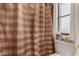 Compact bathroom featuring a tan shower curtain and essential storage solutions at 10410 N Cave Creek Rd # 2030, Phoenix, AZ 85020