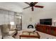 Living room with neutral tones, ceiling fan, fireplace, and sliding glass door to exterior at 10410 N Cave Creek Rd # 2030, Phoenix, AZ 85020