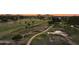Aerial view of lush golf course with meandering path and mountain backdrop at sunset at 12222 N Paradise Village S Pkwy # 442, Phoenix, AZ 85032