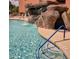 Outdoor pool with a rock waterfall feature and convenient blue grab rails for easy access at 12222 N Paradise Village S Pkwy # 442, Phoenix, AZ 85032