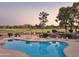 Community pool overlooks manicured green of the golf course and has lounge chairs and umbrellas for relaxation at 12222 N Paradise Village S Pkwy # 442, Phoenix, AZ 85032