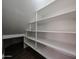 Bright closet with multiple white shelves and dark brown floors at 125 N 22 Pl # 14, Mesa, AZ 85213