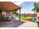 Covered patio and landscaped backyard featuring a pool, barbecue, and turf at 13709 W Rovey Ave, Litchfield Park, AZ 85340