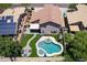 Drone shot of a backyard featuring a pristine pool, patio with seating, and landscaped areas at 13709 W Rovey Ave, Litchfield Park, AZ 85340