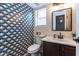 Charming bathroom features patterned wallpaper and updated vanity with a neutral countertop at 13709 W Rovey Ave, Litchfield Park, AZ 85340