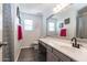 Well-lit bathroom with a long vanity, modern fixtures, and gray plank flooring at 13709 W Rovey Ave, Litchfield Park, AZ 85340