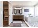 Primary bathroom with double vanity, a walk-in closet and a luxurious soaking tub at 13709 W Rovey Ave, Litchfield Park, AZ 85340