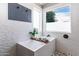 Bright bathroom featuring a modern soaking tub with stylish white tile and a mosaic accent wall at 13709 W Rovey Ave, Litchfield Park, AZ 85340