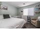 Neutral bedroom featuring a crib, full sized bed, changing table, and accent chair at 13709 W Rovey Ave, Litchfield Park, AZ 85340