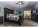 Comfortable main bedroom with a large dark wood bed and a ceiling fan at 13709 W Rovey Ave, Litchfield Park, AZ 85340