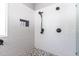 Modern shower featuring white tile, black fixtures, and a mosaic inset for shower products at 13709 W Rovey Ave, Litchfield Park, AZ 85340