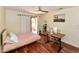 Bright bedroom with a ceiling fan, wood floors, desk with computer and sliding glass doors to a private patio at 14910 N Kings Way # 105, Fountain Hills, AZ 85268