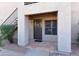 Unit entrance featuring tile entry, security door, and trimmed bushes in gravel yard at 14910 N Kings Way # 105, Fountain Hills, AZ 85268