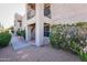 View of a residential two-story building exterior featuring a walkway and blooming bushes in a gravel yard at 14910 N Kings Way # 105, Fountain Hills, AZ 85268