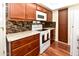 View of kitchen featuring range, tile backsplash, overhead microwave, and wood cabinets at 14910 N Kings Way # 105, Fountain Hills, AZ 85268