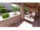 Covered patio with tile floors, exterior stucco wall and porch swing with views of greenery at 14910 N Kings Way # 105, Fountain Hills, AZ 85268
