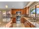 Contemporary kitchen featuring stainless steel appliances, granite countertops, and wooden cabinets at 15232 S 36Th Pl, Phoenix, AZ 85044