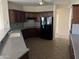 Functional kitchen featuring granite countertops, ample dark wood cabinetry, and modern appliances at 15314 W Camino Estrella Dr, Surprise, AZ 85374