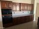 Beautiful kitchen boasts dark wood cabinetry, sleek countertops, and a built-in microwave for convenient cooking at 15314 W Camino Estrella Dr, Surprise, AZ 85374