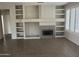Spacious living area with built-in shelving, fireplace, neutral paint, and tile flooring at 15314 W Camino Estrella Dr, Surprise, AZ 85374