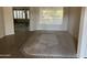 Bright living room with tile flooring, a large window with blinds, and an open floor plan at 15314 W Camino Estrella Dr, Surprise, AZ 85374