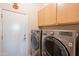 Well-equipped laundry room featuring a modern washer and dryer set with wooden cabinets above at 16333 E Crystal Point Dr, Fountain Hills, AZ 85268