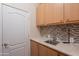 Functional laundry room with a stainless steel sink, mosaic backsplash, and storage cabinets at 16333 E Crystal Point Dr, Fountain Hills, AZ 85268