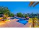Backyard oasis with a pool and desert scenery, illuminated with accent lighting at 16333 E Crystal Point Dr, Fountain Hills, AZ 85268