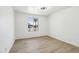 This empty bedroom features wood laminate flooring and a window overlooking the front yard at 1653 E Palmcroft Dr, Tempe, AZ 85282