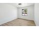 This empty bedroom features wood laminate flooring and a view of the front yard at 1653 E Palmcroft Dr, Tempe, AZ 85282