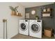 Modern laundry room featuring a stylish backsplash, floating shelves, and front-load washer and dryer at 1653 E Palmcroft Dr, Tempe, AZ 85282