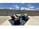 Inviting backyard with lounge furniture set around a gas fire pit on a dark blue outdoor rug at 1661 E Bishop Dr, Tempe, AZ 85282