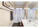 Cozy bathroom with a single sink vanity, toilet, and shower featuring a decorative Parisian themed curtain at 1680 S Arroyo Ln, Gilbert, AZ 85295