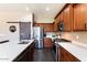 Bright kitchen featuring stainless steel appliances, wood cabinetry, and light countertops and backsplash at 1680 S Arroyo Ln, Gilbert, AZ 85295