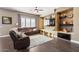Comfortable living room featuring a stone accent wall with built-in shelving and a brown sectional sofa at 1680 S Arroyo Ln, Gilbert, AZ 85295