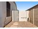 Low-maintenance side yard with gravel landscaping, secure gate, and functional hose storage at 1680 S Arroyo Ln, Gilbert, AZ 85295
